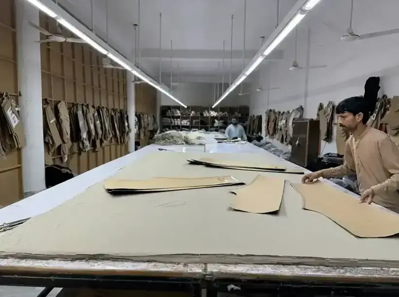 Garment cutting room with fabric spread on long tables and pattern templates at SAS Agencies