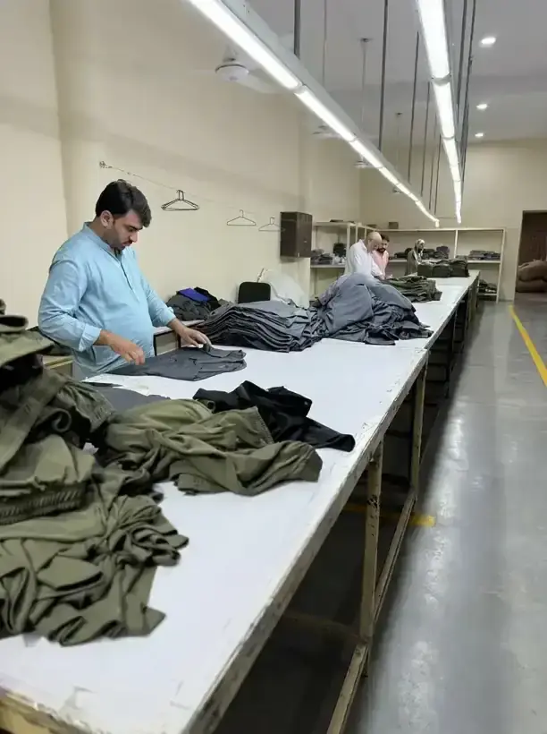 Finishing department folding and stacking trousers at SAS Agencies