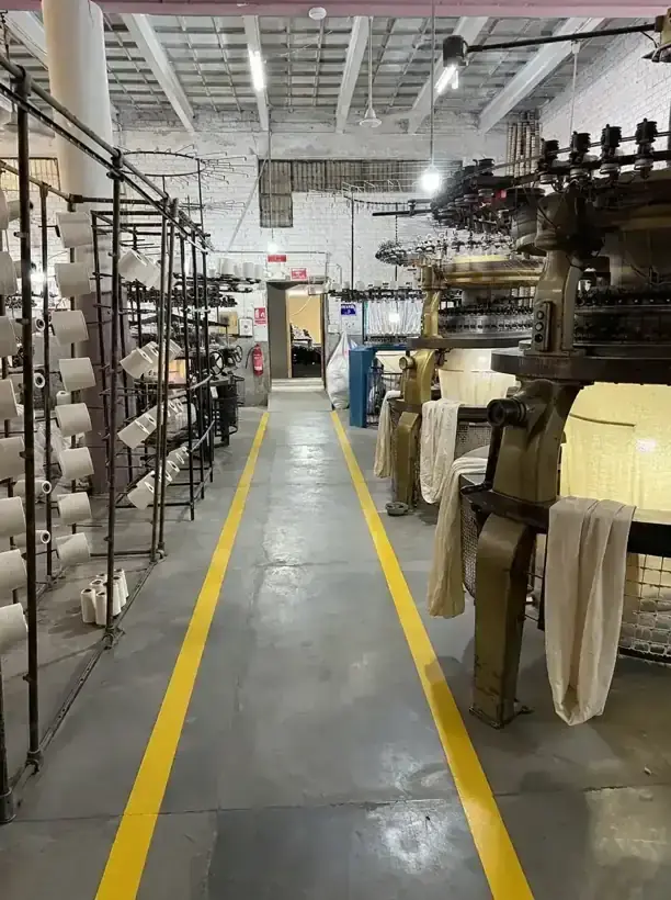 Circular knitting machines producing natural raw cotton fabric at the SAS Agencies factory