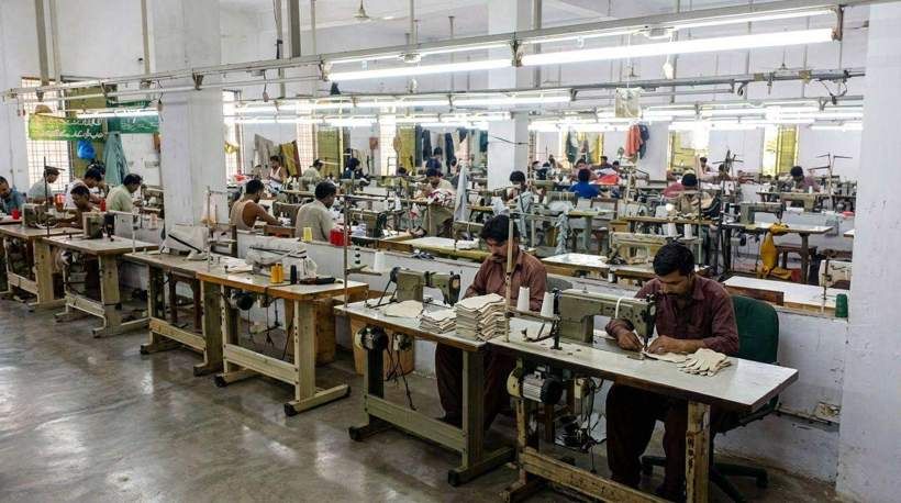 Leather glove stitching hall with rows of industrial sewing operators at SAS Agencies, Faisalabad